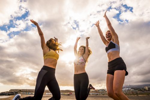 Happy group of females atlethes jumping for win victory concept Happy group of females atlethes jumping for win victory concept and success competition together like a team - joyful for beautiful caucasian people having fun together